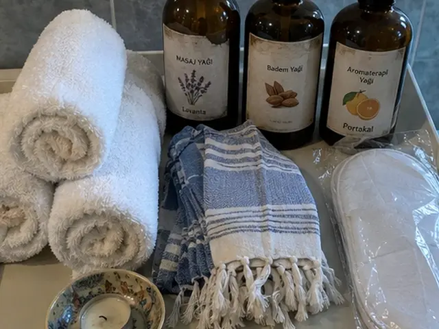 Rulo havlular, mavi peştemal ve aromaterapi yağları — Alipaşa, Masaj Salonun